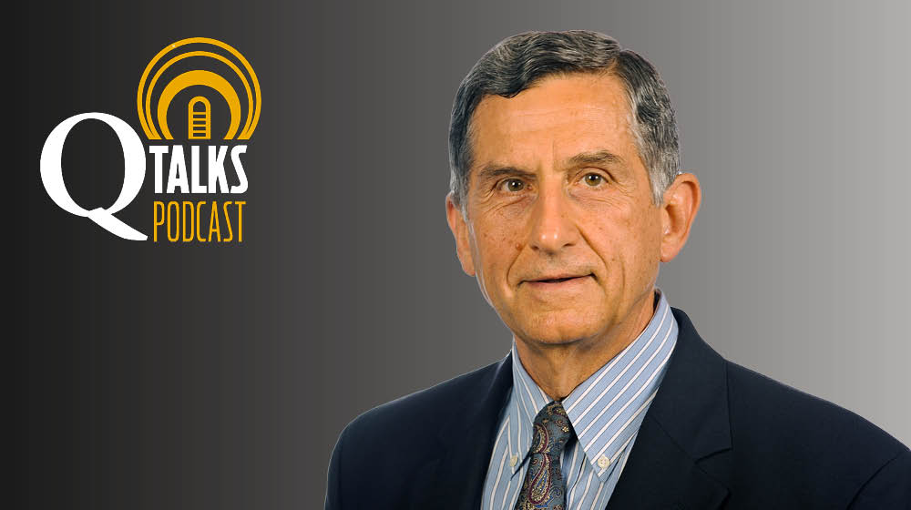 Professor Tassos Malliaris professional headshot against a gray background with the Q Talks Podcast logo